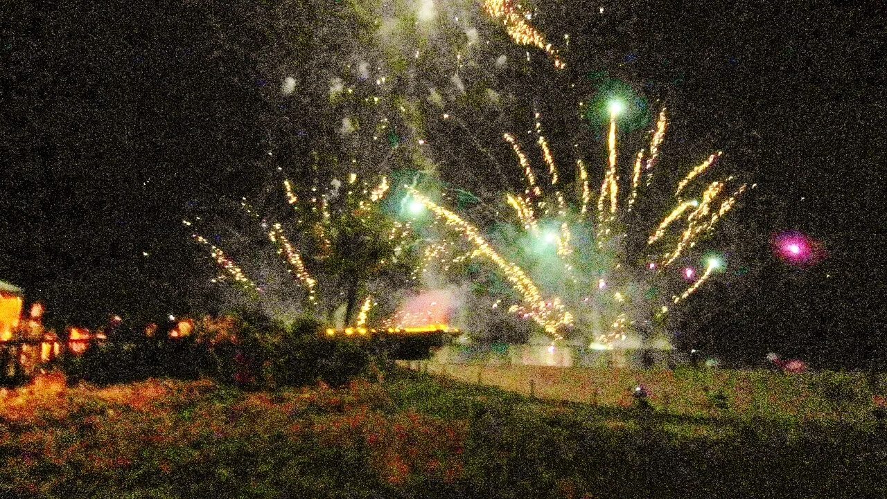 Green and gold fireworks bursting over the dunes at night
