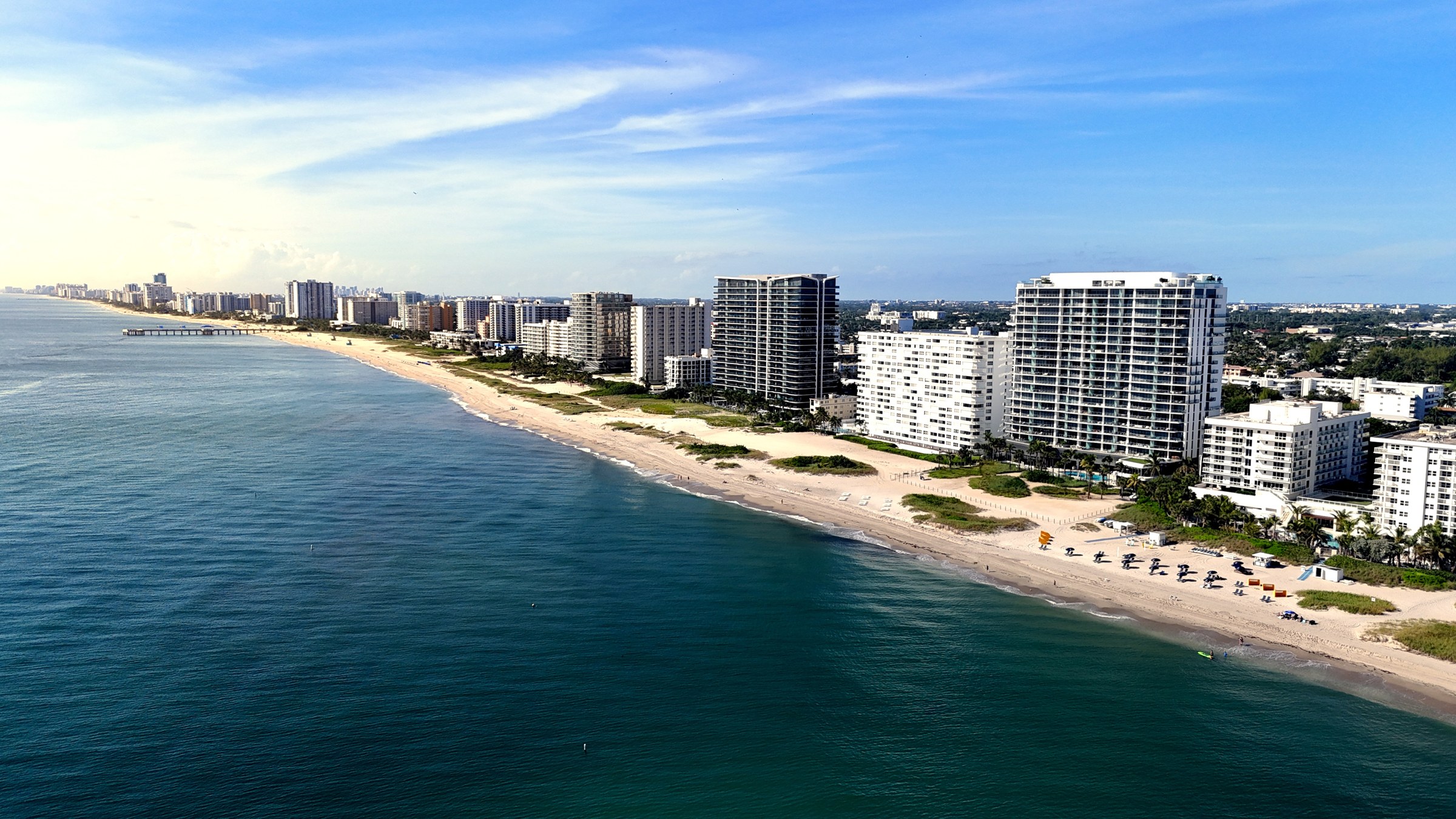 The Pompano Beach oceanfront from the air at sunrise, looking north along the sand to the pier